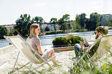 Zwei Studierende am Strand auf dem Campus Wilhelminenhof